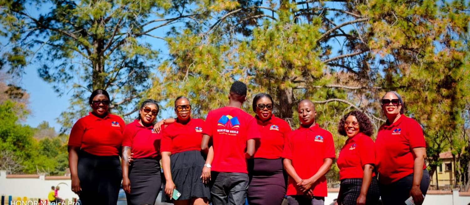 The full Mini Me on Wheels team in red uniform outside a Fourways school