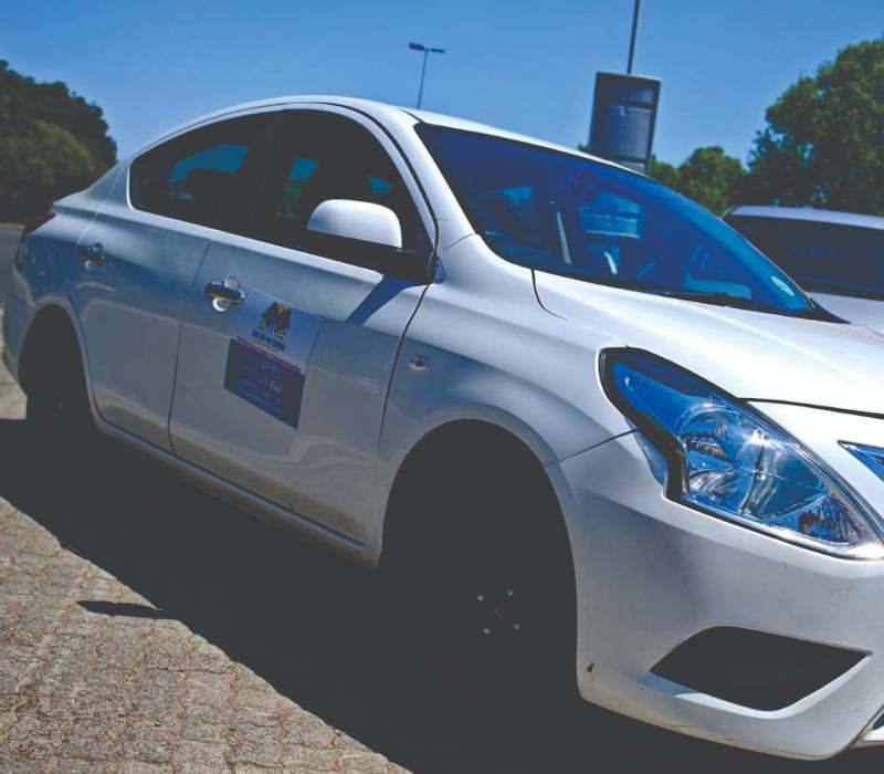 White branded sedan used for airport pickup and drop-off